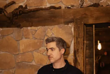 Porträt von DJ Beatgee vor einer Natursteinwand