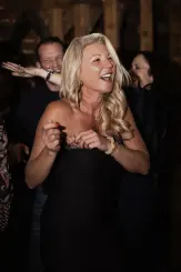 Frau tanzt lachend auf der Tanzfläche