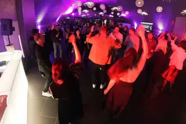 Volle Tanzfläche in violettem und rotem Partylicht