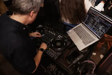 DJ Beatgee am Controller mit Laptop, Blick über die Schulter